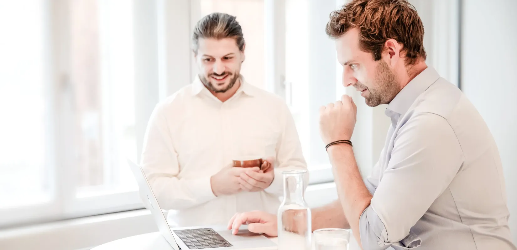 Besprechungssituation mit zwei Personen vor einem Laptop